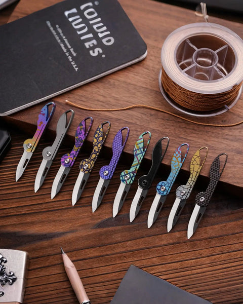 Colorful mini titanium pocket knives for everyday carry with razor sharp folding blade on wooden desk