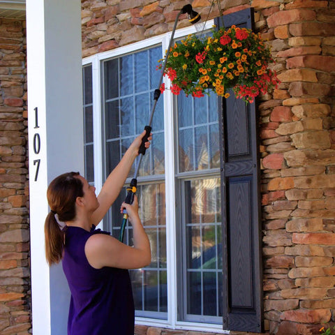 Woman using RelaxGrip No Sweat Eight Pattern Pivoting Head Watering Wand With Quick Connect Extension Extends From 33 To 48 Inches