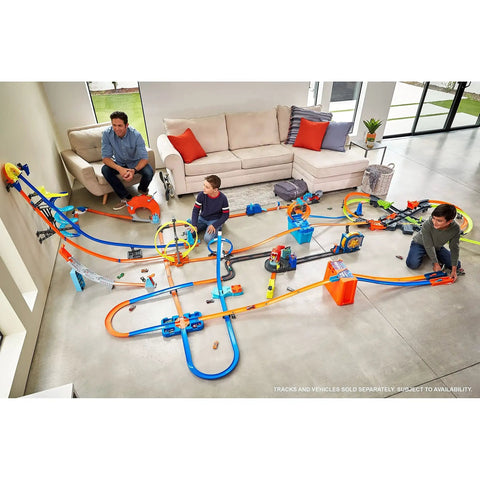 Children playing with Deluxe Stunt Box Track Builder Playset with 25 parts and a 1 to 64 scale vehicle in a living room.