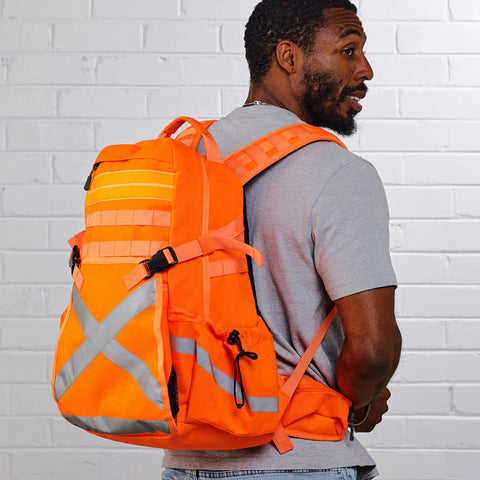 Man wearing Hi Vis Orange Safety Backpack With Reflective Panels, Adjustable Hard Hat Holder, and Bottle Holders for construction use.