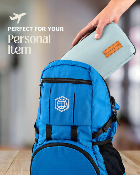 Hand placing Compact Travel Tech Organizer Bag For Cables Chargers And Gadgets With Leather Accents into blue backpack