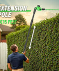 Man using Cordless 18 Inch Hedge Trimmer with Extension Pole and 16 Foot Reach for multi angle cutting on tall hedges