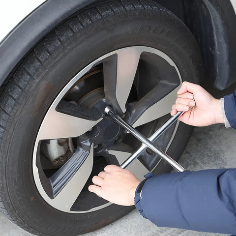 Using the 14 Inch Cross Lug Wrench With 4 Way Sockets for easy tire changes, demonstrating max torque on a stubborn lug nut.