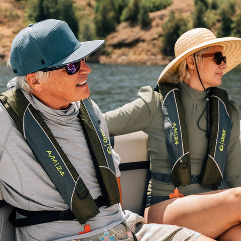 Two adults wearing USCG Approved Inflatable Life Jacket for Adults Go To Auto Or Manual Inflation Green 30 To 52 Inch Chest