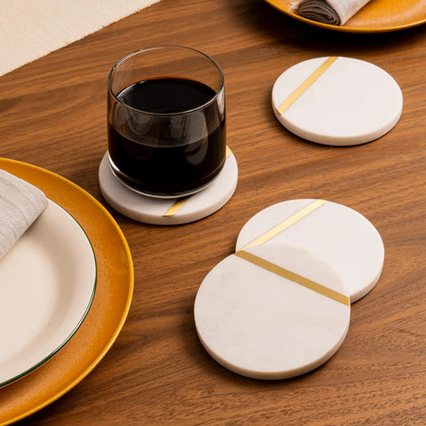 Dope White Marble Coasters Set Of 6 With Gold Brass Inlay For Luxury Aesthetic Modern Coffee Table Decor Real Natural Semi Absorbent Stone Drink Coasters Premium Quality displayed on wooden table with glass and plates.