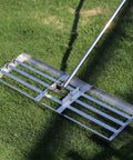 Heavy Duty Lawn Leveler Rake With 304 Stainless Steel Head, 30 Inch Wide, 6.5 Foot Ergonomic Handle resting on grass