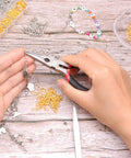 Person using pliers on jewelry piece with Jump Ring Kit For Jewelry Making With 1200 Open Jump Rings And Clasp Set, Necklace And Bracelet Repair Supplies, Includes Pliers And Tweezers In Gold And Silver
