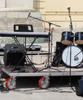Heavy Duty Eight By Two Inch Industrial Casters Polyurethane And Steel Wheels Six Thousand Pound Capacity Built Tough For Shop Carts And Utility Dollies Rolls Easy No Sweat Swivel Lock Brakes Pack Of Four on a stage platform with musical equipment.