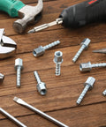 100 Piece Heavy Duty Zinc Steel Concrete Anchors, 3/8 Inch Threaded Rod With 1/4 Inch Diameter And 1-1/2 Inch Length screws and tools on wood surface.