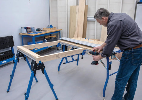 Man using a drill on adaptive cutting system extension brackets on a workbench. Level Up Your Shop Rig With These Knockout Adaptive Cutting System Extension Brackets That Bolt Right Onto Standard Workbenches Or Portable Project Tables For Quick Setup.