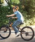 Child riding a bike equipped with Two Pack 20 Inch Heavy Duty Bicycle Tubes With TR4A-40L Schrader Valve Fits 20 X 1.75 1.90 1.95 2.0 2.125 2.25 Tires 45/57-406 Durable Inner Tubes For Mountain And City Rides on a sunny day.