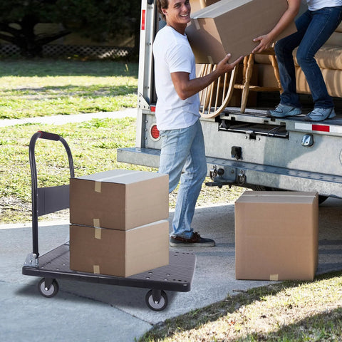 Foldable Heavy Duty Push Cart Dolly With 660 Lb Capacity And Swivel Wheels for loading boxes into a truck in a driveway setting.