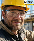 Built Like A Tank 12 Pack Safety Glasses With Anti Fog Coating And UV Protection Scratch Resistant Polycarbonate Lenses All Day Adjustable Fit For Rough Crews Outdoors worn by a worker with a yellow hard hat.