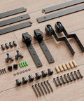 Bypass Sliding Barn Door Hardware Kit with Single Track System, carbon steel, frosted black, components laid out on the floor.