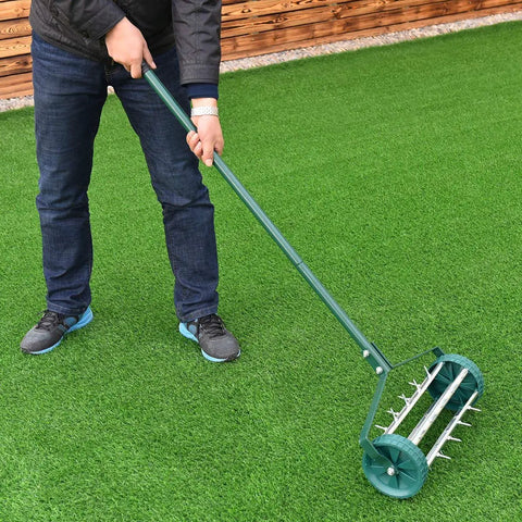 Person using a Rolling Lawn Aerator 18 Inch With Heavy Duty Spiked Tines For Deep Soil Aeration Manual Push Rotary Tool With 41 Inch Handle