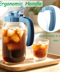 Two Pack 64 Oz Wide Mouth Pitchers With Stainless Steel Filters, ergonomic handle full of iced coffee on a wooden tray