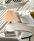 Pleated Ceramic Table Lamp With Tricolor Led Bulb For Living Room Decor on coffee table with books and sofa