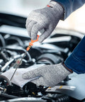 Person wearing grey Level 5 cut resistant kitchen gloves checking car engine with screwdriver, showcasing grippy flexible grip.