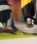 FURNO 700 Digital Heat Gun With 2 Nozzles removes paint as person scrapes paint from wood surface, emphasizing adjustable temperature control.