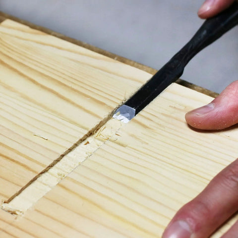 Person using chisel on wood from Beginner Friendly Japanese Woodworking Hand Tool Set 7 Piece Includes Plane Chisels Pull Saw Hammer Marking Gauge And Carry Bag All In One Starter Kit Made In Japan For DIY Woodworking Fans