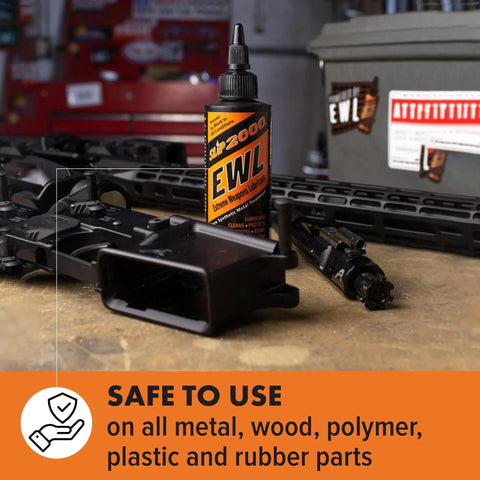 Extreme Weapons Lubricant EWL Synthetic CLP Gun Lube Spray 16oz bottle with rifle parts on workbench