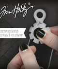 Hands using paper distressing tool with 7 recessed blades for scrapbooking, creating rough torn edges and vintage texture on cardstock.