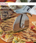 Pizza Cutter Roller Wheel With Sharp Blade For Crusts And Pies slicing quesadillas on a wooden board.