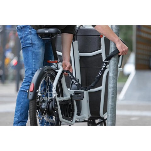 Person securing bicycle with 100 cm Plug-In Chain Bike Lock With 5.5 MM Hardened Steel Links.