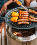 Bonfire Cast Iron Grill Cooking Bundle 2.0 With Smokeless Fire Pit Stand and veggies grilling on cast iron plate