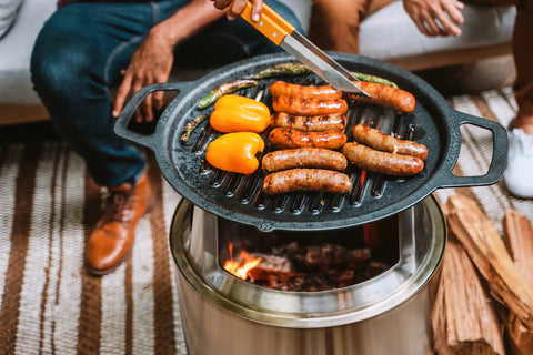 Bonfire Cast Iron Grill Cooking Bundle 2.0 With Smokeless Fire Pit Stand and veggies grilling on cast iron plate
