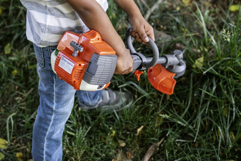Child using 223L Toy Trimmer With Realistic Sounds And Light Up Trimmer Line For Kids Ages 3 And Up A Kid Friendly Weed Eater Play Tool.