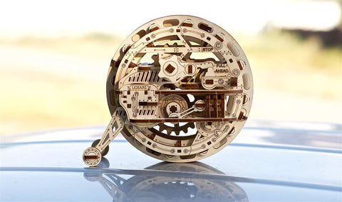 Mechanical Wooden 3D Puzzle Model Monowheel Construction Set For Gearhead Builders With A Steampunk Skeleton Showcasing Moving Dope Gears Durable Outdoor Ready So You Can Roll It On The Street Or Desk A Fun STEM Toy, side view on desk