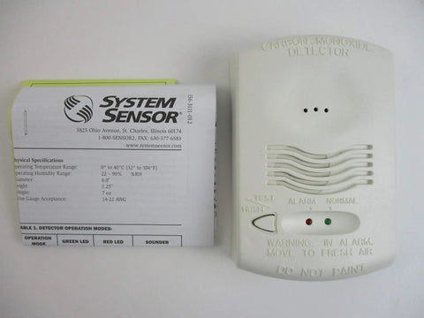 Front view of 12 24V 4 Wire System Monitored Carbon Monoxide Detector With RealTest Technology next to instruction manual.