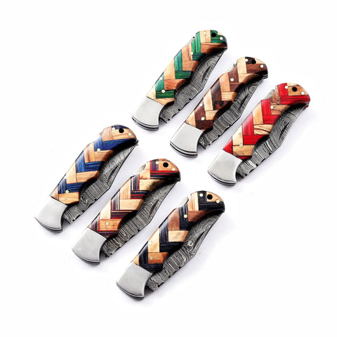 Colorful handles of handmade Damascus pocket folding knives with olive wood for EDC and camping. 150 layer Damascus blade in view.