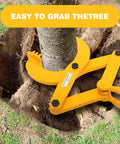 Yellow tree puller tool gripping a small tree trunk firmly in a dug-out soil area