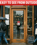 Back In A Bit Adjustable Clock Sign on bookstore door, visible through glass; two sided plastic return sign with twine and suction cup hook.