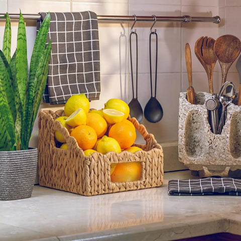 Set Of 2 Scalloped Wicker Storage Baskets With Handles For Food Organization, filled with lemons and oranges on a kitchen counter.