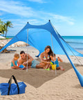 Family under Ultra Portable Beach Tent Canopy With UPF50 Sun Protection, Pop Up Beach Shade For Outdoor Camping, on beach with sandbags and ropes