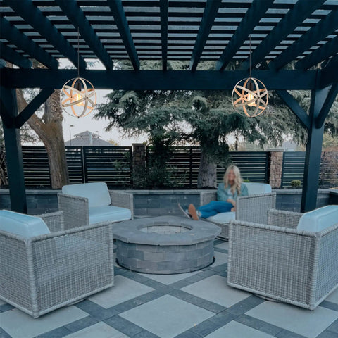 Outdoor seating area with Industrial Spherical Pendant Light With Changeable Cage Design above a fire pit under pergola.