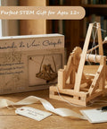 Leonardo Da Vinci Catapult Kit Build a Working Wooden Siege Engine on display with box and accessories on wooden table.