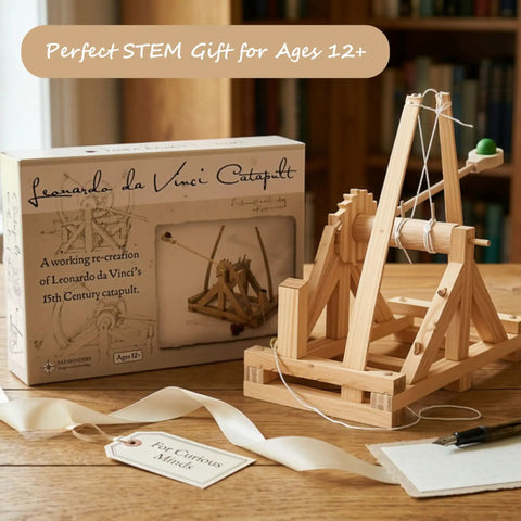 Leonardo Da Vinci Catapult Kit Build a Working Wooden Siege Engine on display with box and accessories on wooden table.