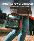 Person holding Solar Generator 240 V2 With 256Wh LiFePO4 Battery And 300W AC 100W USB C Output, ideal for outdoor use