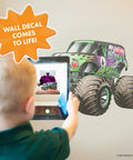 Child interacts with Grave Digger Monster Jam Wall Decal With 3D Augmented Reality Interaction Peel And Stick 28 Inch Epic Wall Decor.