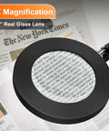 5X Magnifying Lamp With Clamp And Dimmable LED Light showing clear close-up of newspaper text for detailed work.