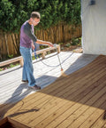 Man using Zero Sweat Heavy Duty Airless Paint Sprayer With Adjustable Pressure Control Spray Unthinned Stains on deck surface.