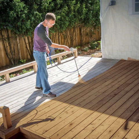 Man using Zero Sweat Heavy Duty Airless Paint Sprayer With Adjustable Pressure Control Spray Unthinned Stains on deck surface.
