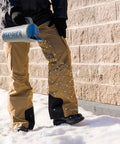 Person using Spot Spreader 80 Oz Handheld Grab-And-Go Dispenser for salt on snowy ground with multi-size openings.