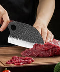 Person using Serbian Chef Cleaver Knife With Leather Sheath 5.8 Inch Hammered 3CR13 Blade to slice meat on wooden board.