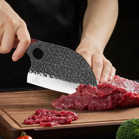 Person using Serbian Chef Cleaver Knife With Leather Sheath 5.8 Inch Hammered 3CR13 Blade to slice meat on wooden board.