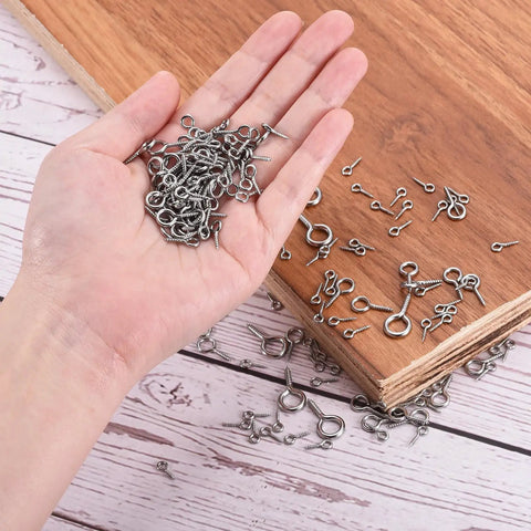Top Shelf 304 Stainless Steel Eye Screws held in a hand, mini eye pins for DIY crafts and jewelry making.
